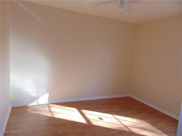 unfurnished room featuring ceiling fan, wood finished floors, and baseboards