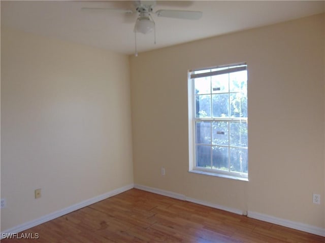 empty room with plenty of natural light, baseboards, and wood finished floors