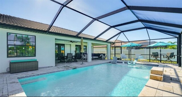 view of swimming pool with a fenced in pool, a lanai, a patio, and ceiling fan