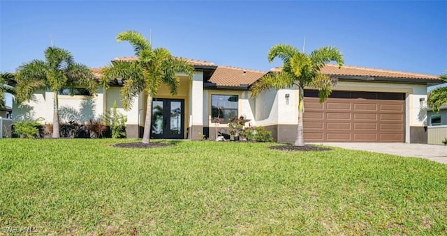 view of front facade featuring an attached garage, driveway, french doors, stucco siding, and a front yard