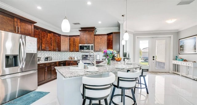 kitchen with visible vents, appliances with stainless steel finishes, ornamental molding, a sink, and light stone countertops