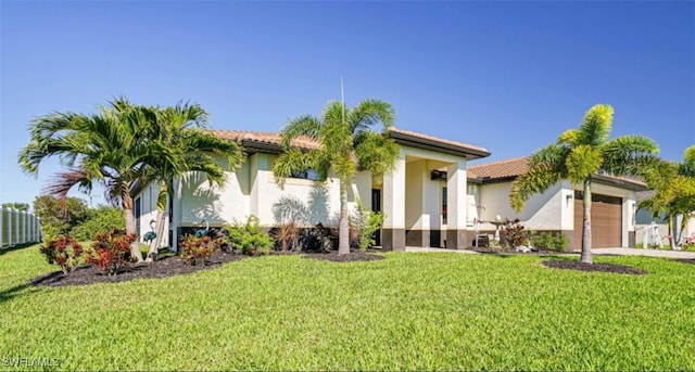 mediterranean / spanish home with a front yard, driveway, an attached garage, and stucco siding