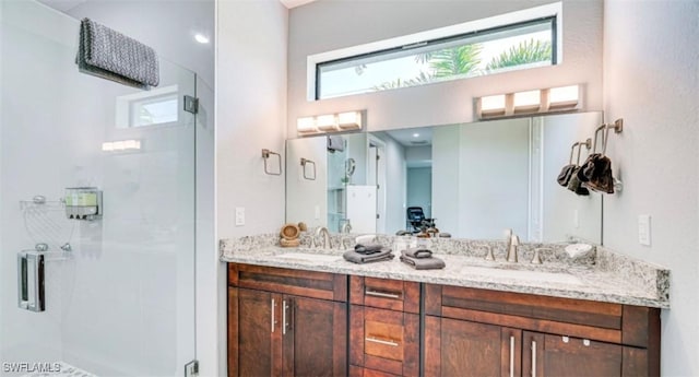 full bathroom featuring a stall shower, a sink, and double vanity