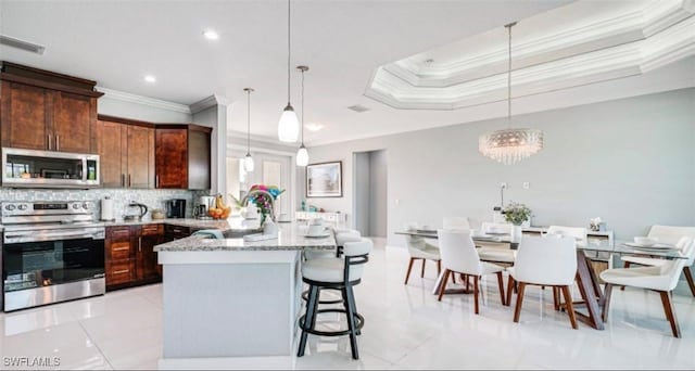 kitchen with visible vents, decorative backsplash, ornamental molding, a peninsula, and stainless steel appliances