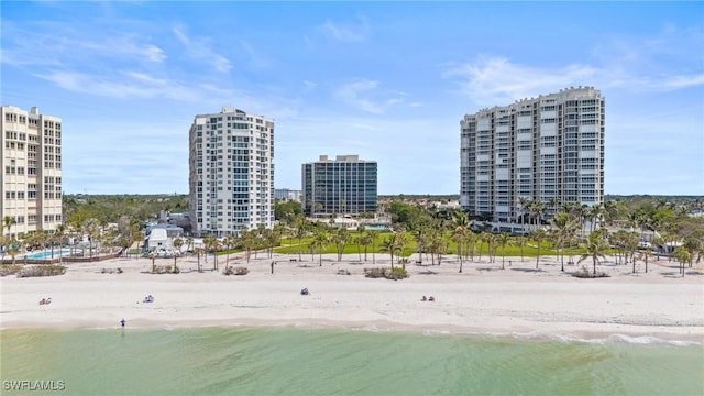 birds eye view of property with a beach view, a water view, and a city view