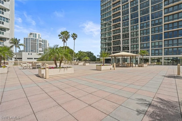 surrounding community with a view of city, a patio, and a gazebo