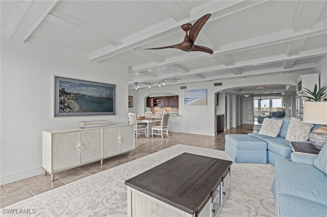 living room featuring a ceiling fan, arched walkways, beam ceiling, and coffered ceiling