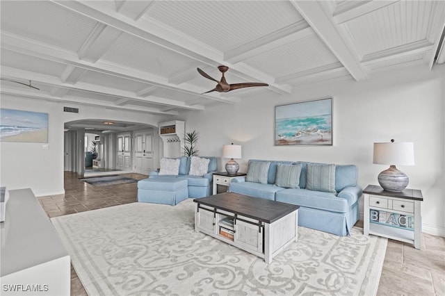 living room with arched walkways, beam ceiling, ceiling fan, coffered ceiling, and baseboards