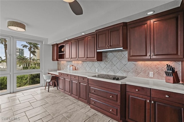 kitchen with black electric cooktop, under cabinet range hood, light countertops, backsplash, and open shelves