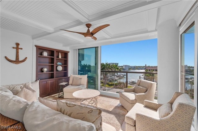 living area featuring beamed ceiling, coffered ceiling, a ceiling fan, and a water view