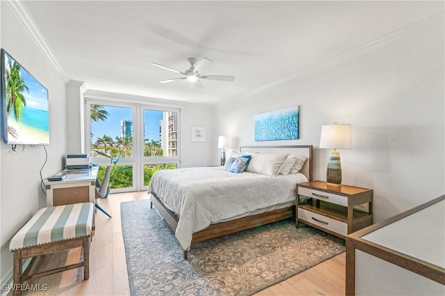 bedroom featuring wood finished floors, a ceiling fan, and crown molding