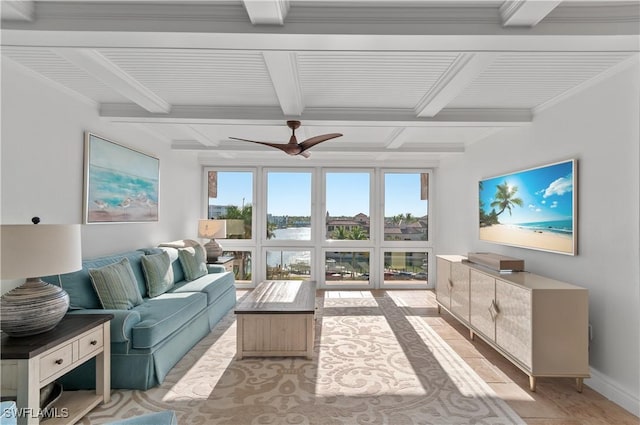 living room with a ceiling fan, baseboards, beam ceiling, and light wood-type flooring