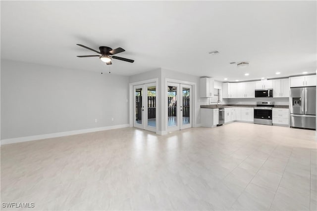 unfurnished living room with visible vents, a sink, recessed lighting, french doors, and baseboards