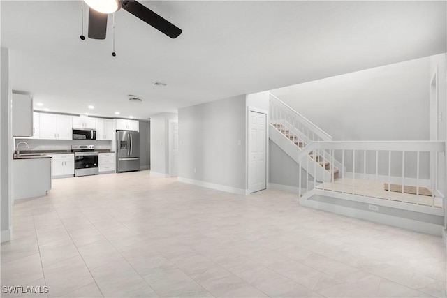 unfurnished living room with stairway, recessed lighting, baseboards, and a sink