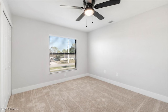 unfurnished room featuring carpet flooring, visible vents, baseboards, and ceiling fan