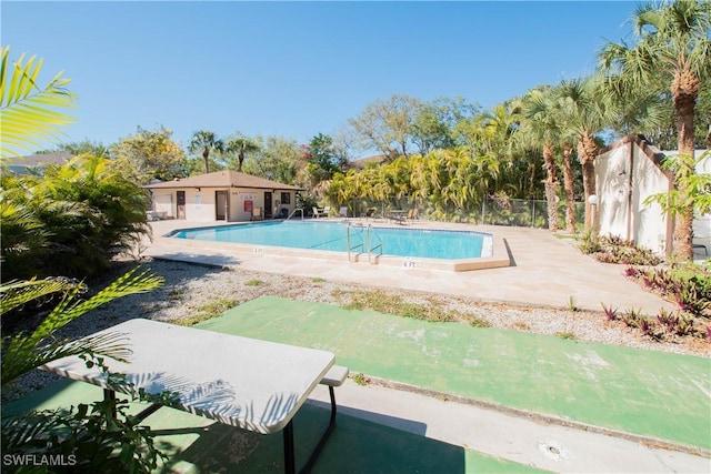 pool with fence and a patio area