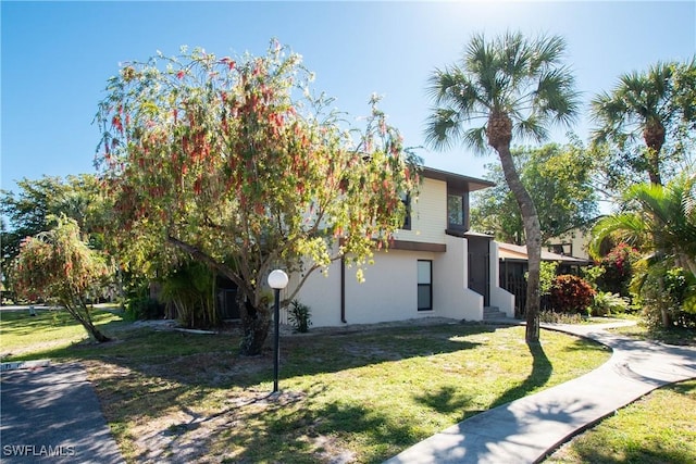 view of home's exterior with a lawn and stucco siding