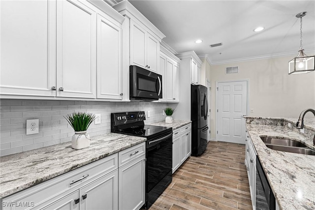 kitchen featuring ornamental molding, a sink, black appliances, white cabinets, and tasteful backsplash