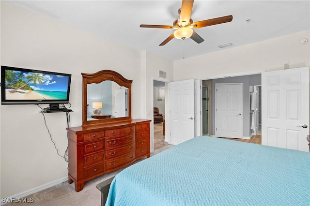 bedroom featuring visible vents, light colored carpet, baseboards, and ceiling fan