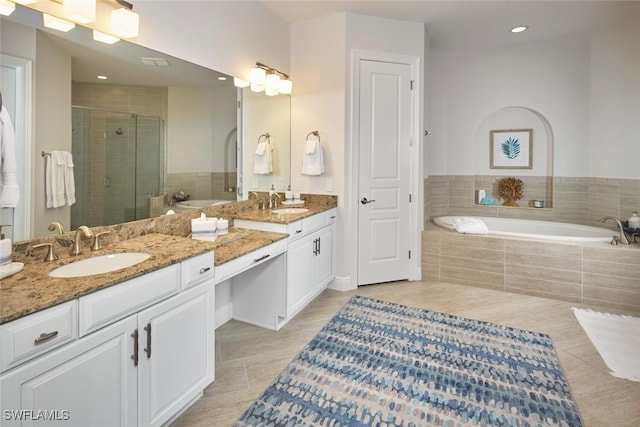 full bath with double vanity, a stall shower, a sink, tile patterned flooring, and a garden tub