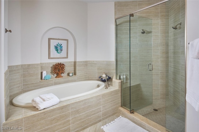 full bathroom featuring a shower stall and a garden tub