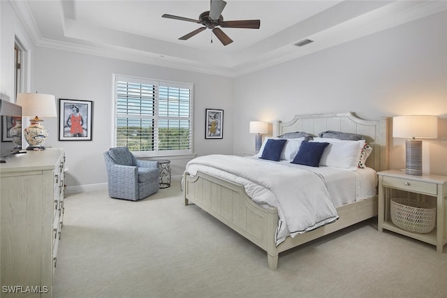 bedroom with a ceiling fan, baseboards, visible vents, a tray ceiling, and light carpet