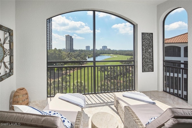 sunroom featuring a water view and a city view