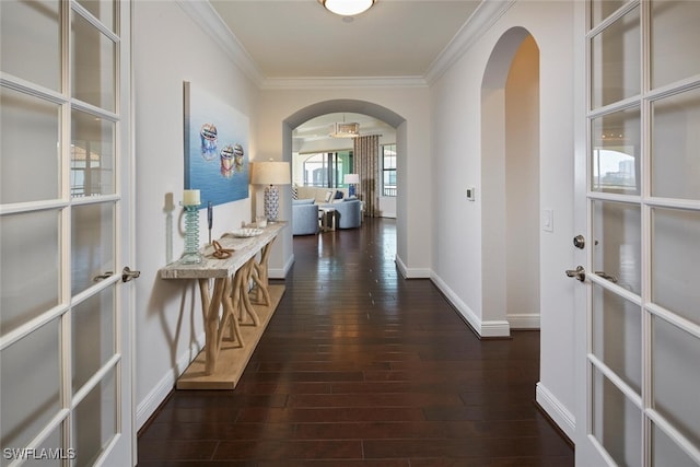 corridor with baseboards, arched walkways, hardwood / wood-style floors, and crown molding