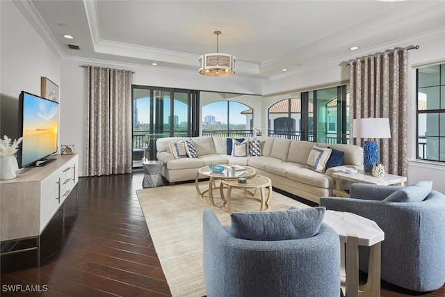 living area featuring visible vents, dark wood finished floors, ornamental molding, recessed lighting, and a raised ceiling