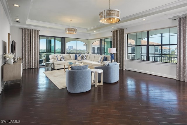 living area featuring visible vents, ornamental molding, a tray ceiling, and wood finished floors