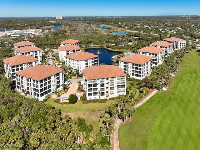 drone / aerial view with view of golf course and a water view