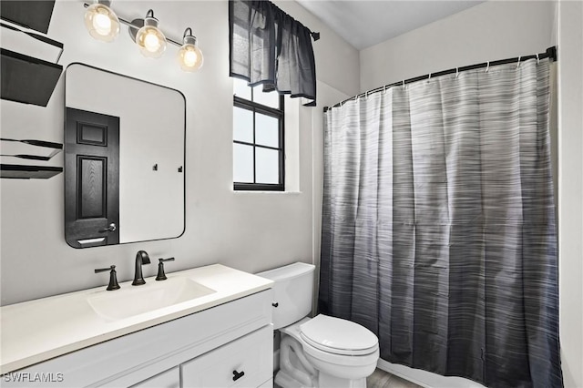 bathroom featuring a shower with shower curtain, toilet, and vanity