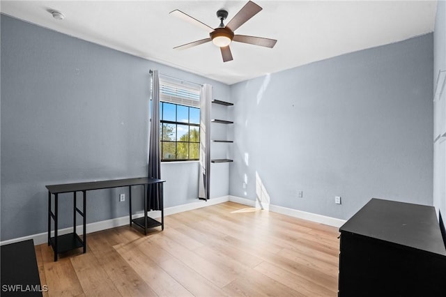 spare room featuring a ceiling fan, baseboards, and wood finished floors