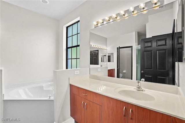 bathroom featuring a shower stall, vanity, and a garden tub