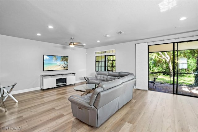 living room with light wood-type flooring, visible vents, recessed lighting, a fireplace, and baseboards