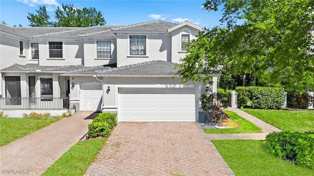 view of front of property featuring decorative driveway, stucco siding, and a tile roof