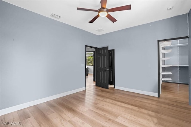 spare room with a ceiling fan, baseboards, visible vents, and light wood finished floors