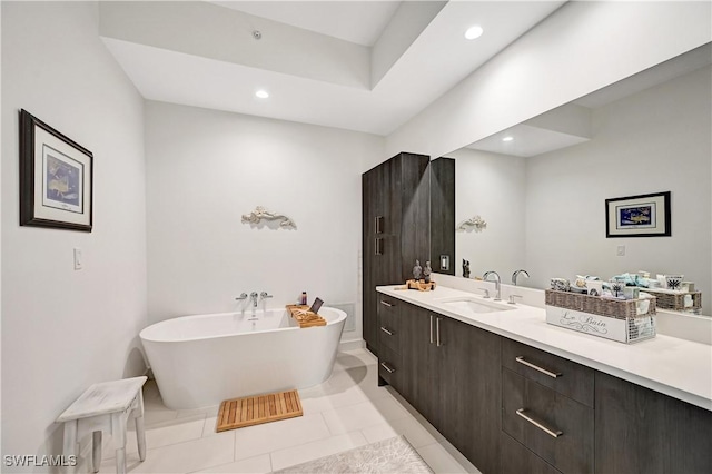 bathroom featuring a freestanding bath, tile patterned floors, vanity, and recessed lighting