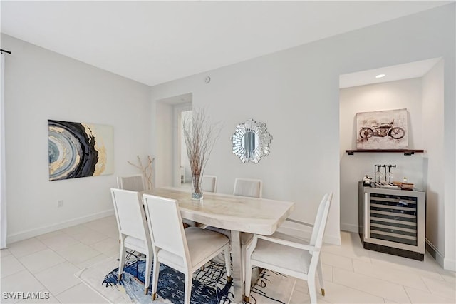 dining space with light tile patterned floors, beverage cooler, and baseboards