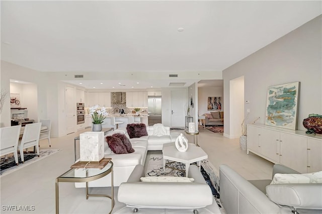 living area featuring visible vents and recessed lighting