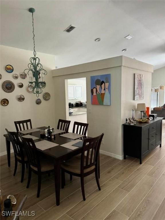 dining area featuring visible vents, baseboards, and wood finish floors