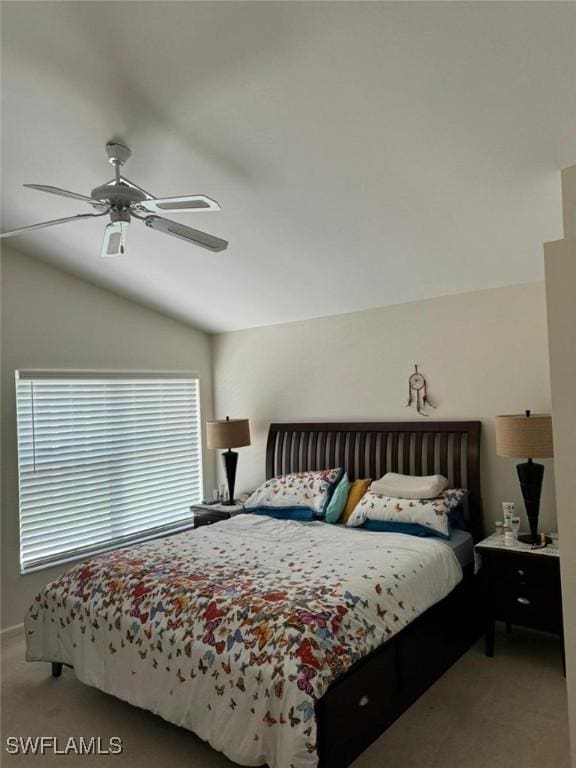 bedroom with a ceiling fan, lofted ceiling, and carpet flooring