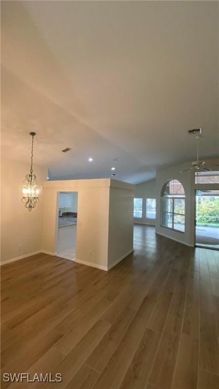 unfurnished room featuring a chandelier, visible vents, baseboards, and wood finished floors