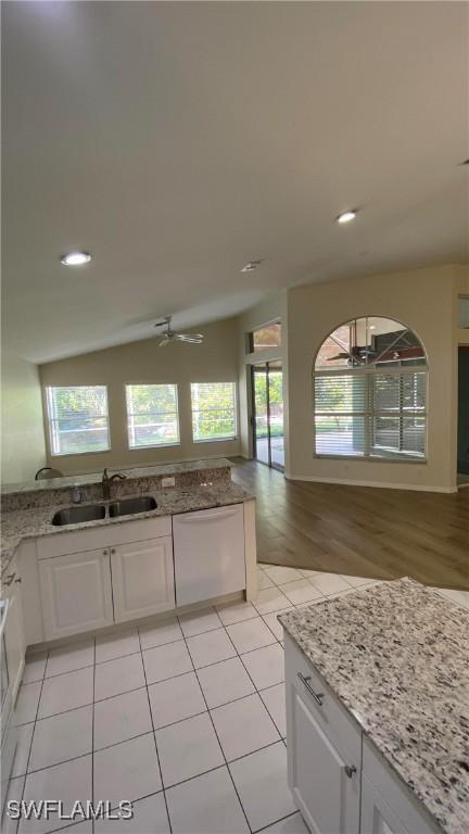 kitchen featuring plenty of natural light, white cabinets, a sink, and dishwasher