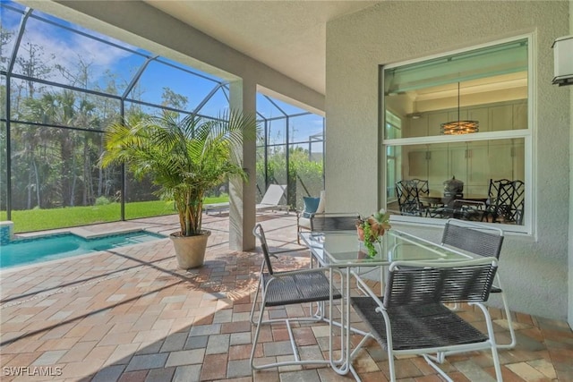 view of patio / terrace featuring glass enclosure and an outdoor pool