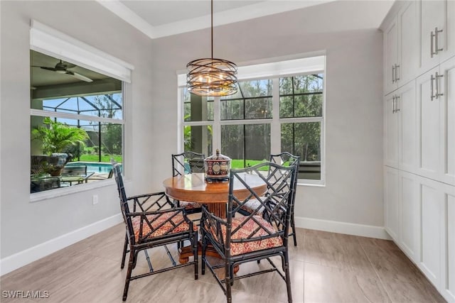 dining area with light wood-style flooring, baseboards, and ceiling fan with notable chandelier