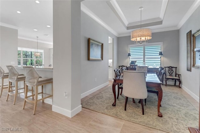 dining room with crown molding, baseboards, a raised ceiling, and a notable chandelier