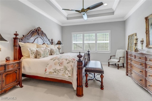 bedroom with a ceiling fan, a raised ceiling, crown molding, and light colored carpet