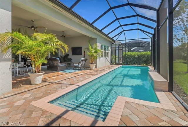 outdoor pool with ceiling fan and a patio area