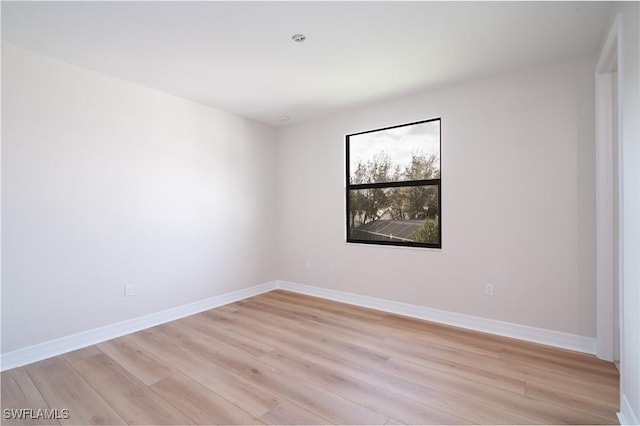 unfurnished room with light wood-type flooring and baseboards